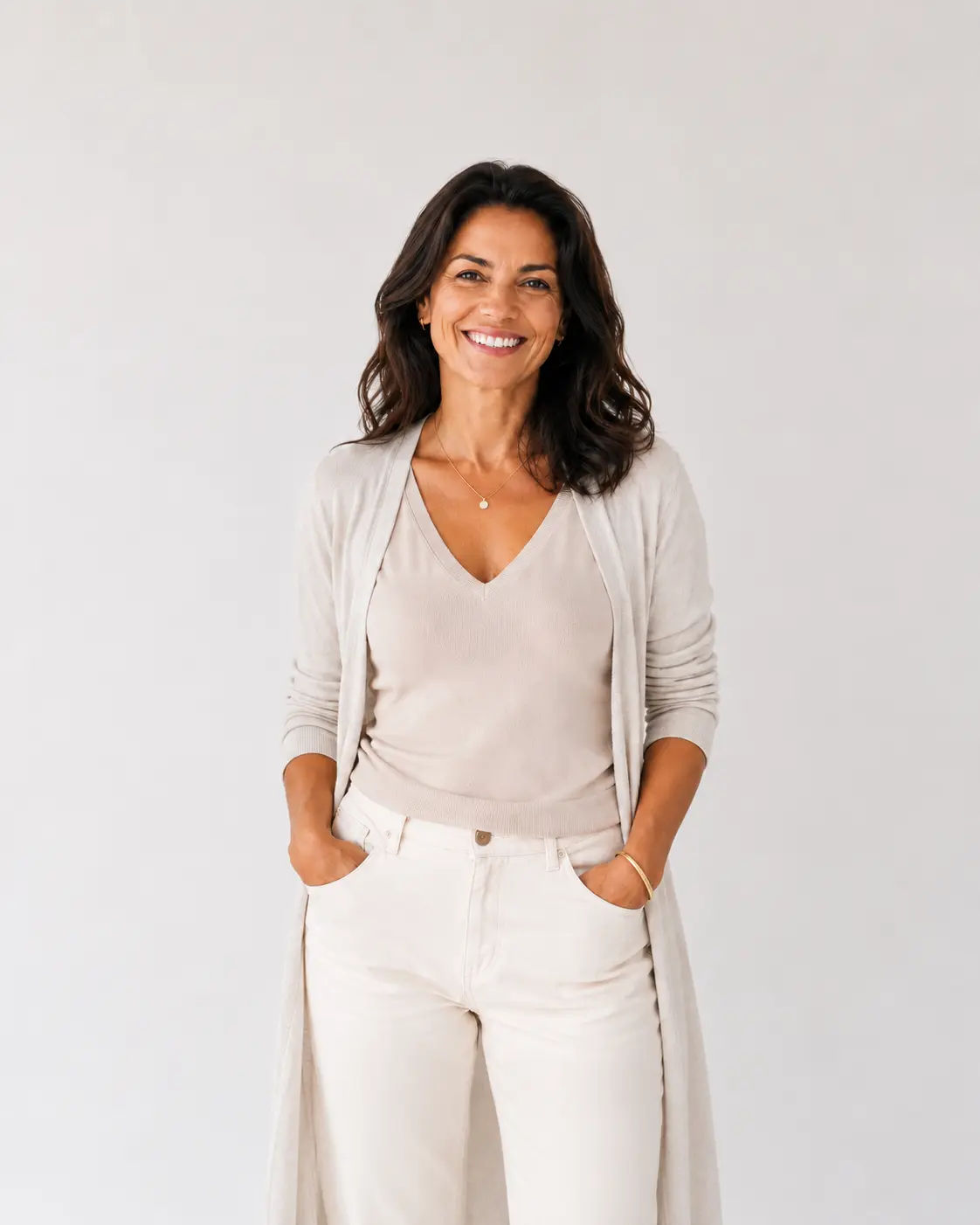 Mulher de meia-idade sorrindo, com aparência saudável e confiante, em fundo claro, representando atendimento em nutrologia no Rio de Janeiro.