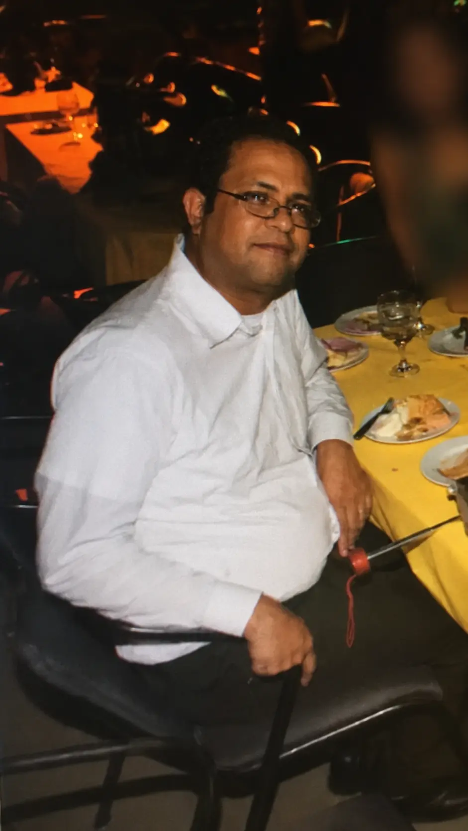 Dr. Noé Alvarenga sentado em um restaurante, em fotografia de arquivo de sua trajetória pessoal.